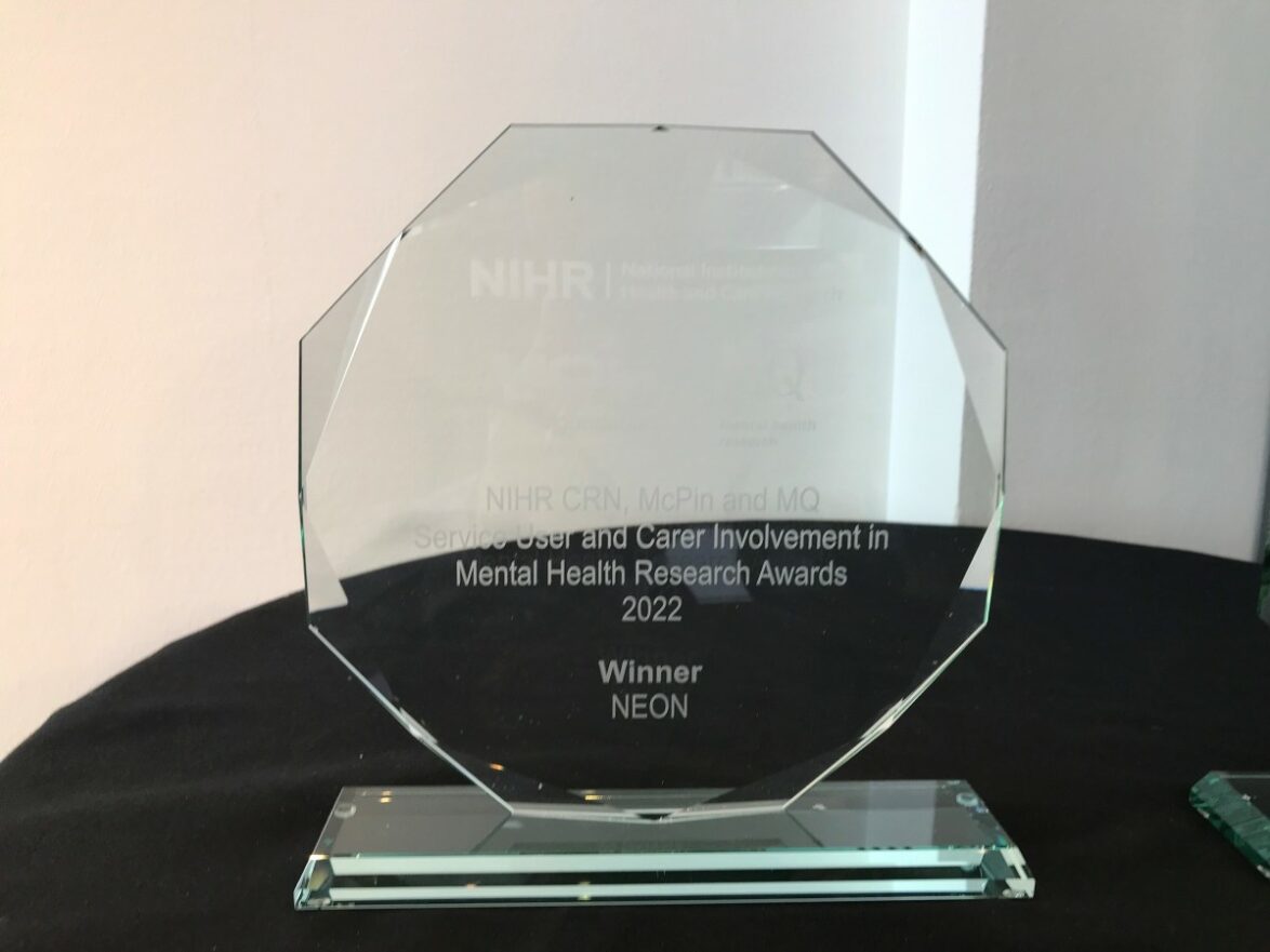 A large glass award inscribed: NIHR CRN, McPin and MQ Service User and Carer Involvement in Mental Health Research Awards 2022. Winner: NEON.
