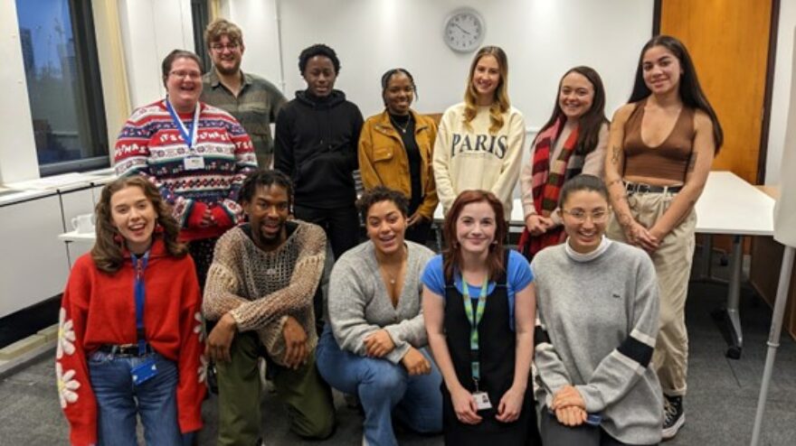 A photo of 12 young people and members of the McPin Young People's team stood in a group smiling at the camera